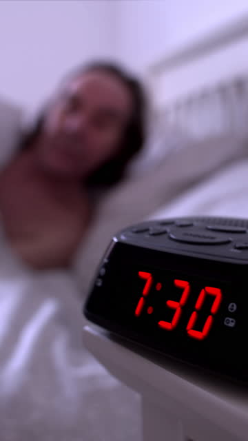 Waking up. Digital alarm clock, time from 7.29 to 7.30.
