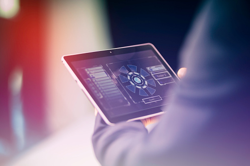 Close-up photo of a caucasian businessman's hand while using a digital tablet.