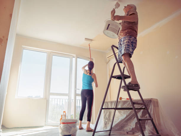 istock People painting living room wall during flat improvement 1306523038