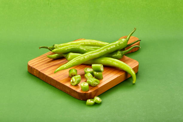 Green chilli Green chillies on cutting boarding green paper green chilli pepper stock pictures, royalty-free photos & images