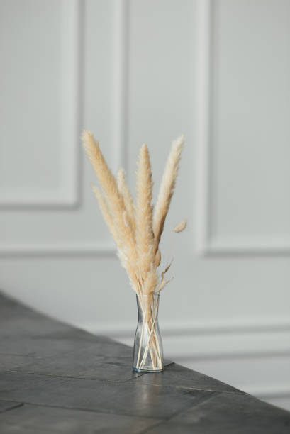 istock Dried flowers in a glass vase stand on a dark surface 1306526519