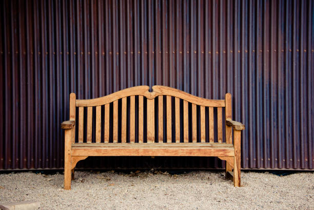 istock Rusted Corrugated Metal Wall with Wooden Bench 1306528014