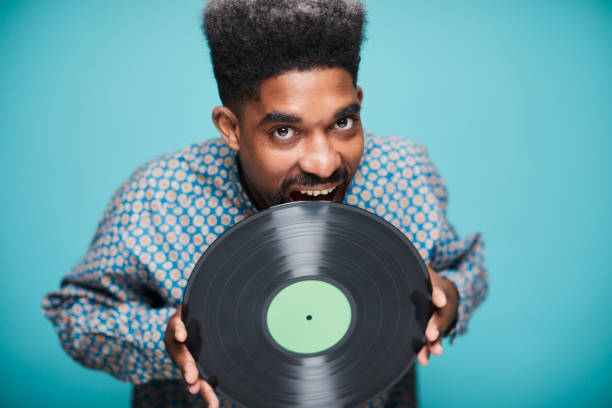 istock Funky musician biting a long play record 1306528489
