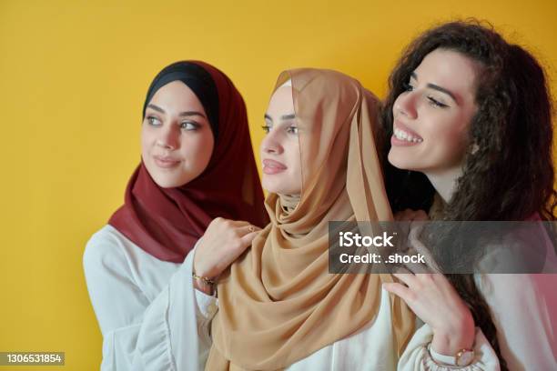 Young Muslim Women Posing On Yellow Background Stock Photo - Download Image Now - Women, Middle Eastern Ethnicity, Modern