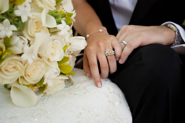istock Bride and Groom Hands with Rings and Bouquet 1306532272