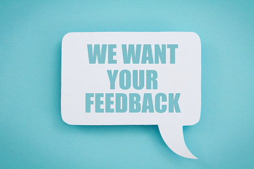 We want your feedback written in a white speech bubble, on a blue background.
Customer feedback concept.