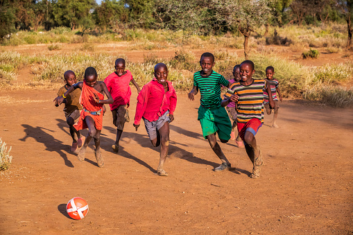 African children from Masai tribe playing football in the village near Mount Kilimanjaro, East Africa, Kenya, East Africa. Maasai tribe inhabiting southern Kenya and northern Tanzania, and they are related to the Samburu.