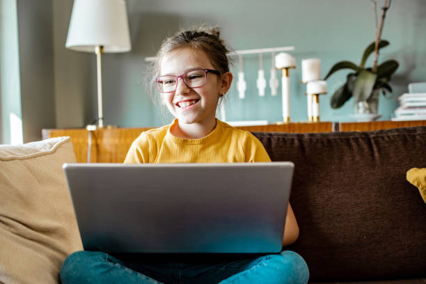 istock Little girl is using laptop at home 1306534935