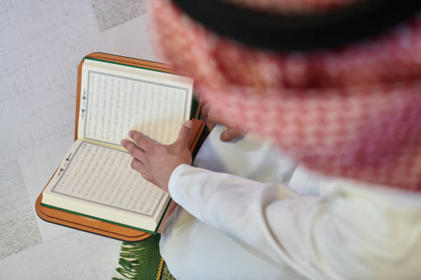istock Young muslim man reading Quran during Ramadan 1306535188