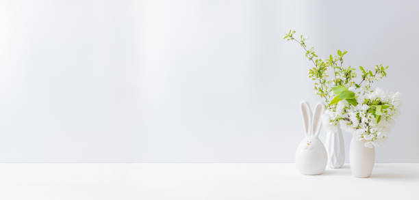 istock Home interior with easter decor. Spring flowers in a vase on a light background 1306535235