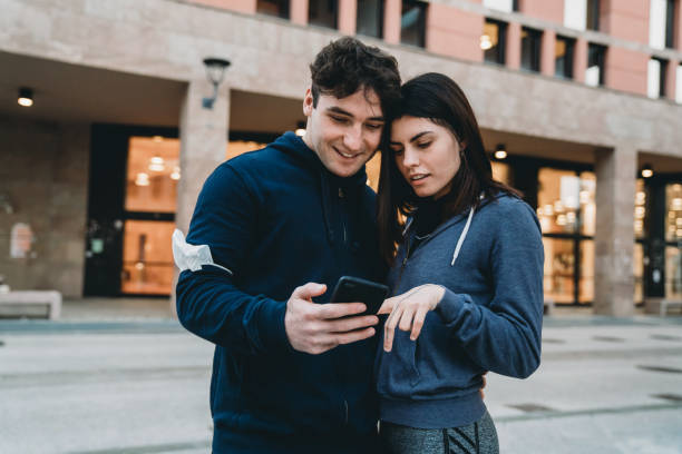 istock Young adult couple taking a break and looking a smartphone during an exercising session 1306537406