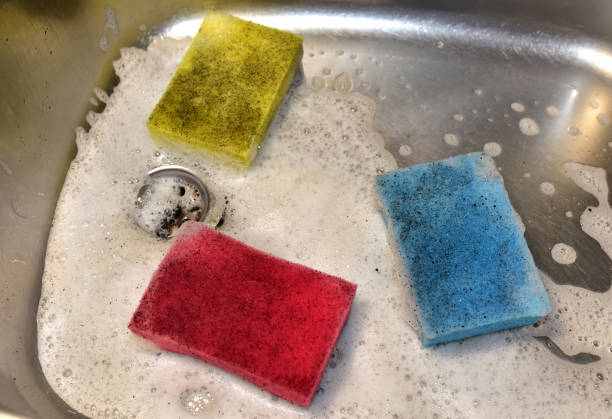 istock Sponge with detergent and foam while washing the sink in the kitchen 1306538325