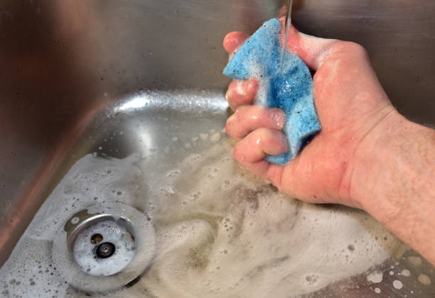 istock Sponge with detergent and foam while washing the sink in the kitchen 1306538331