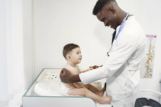 istock African doctor examines a little boy on couch 1306538418
