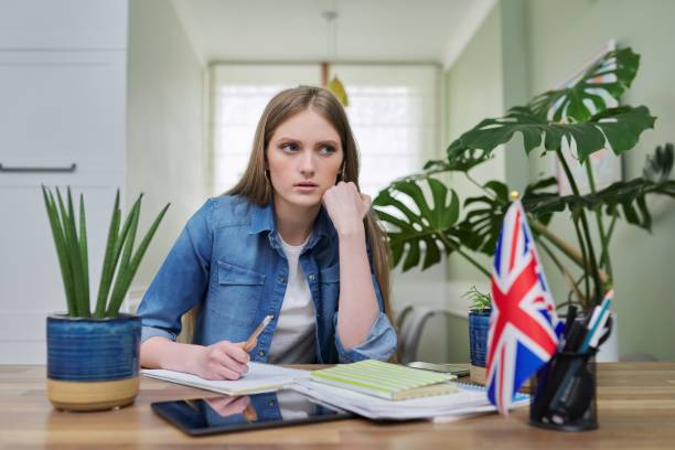 istock UK learning English online. Female student remotely looking at webcam 1306539165