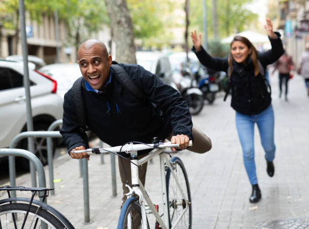 istock Man stealing bicycle, woman owner running after 1306541742