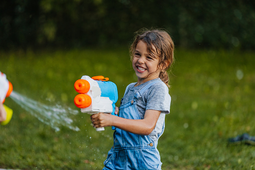 Boy playing with a water gun at the backyard