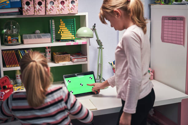 istock Little Girls Doing Home Schooling with Tablet Green Screen 1306542746