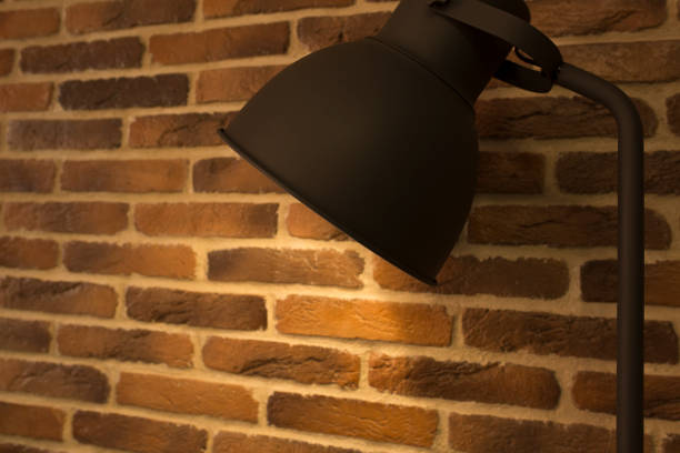 istock Old style desk lamp on a background of brick wall 1306542882