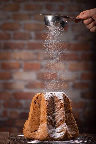 Pandoro with dusting of icing sugar on dark background.