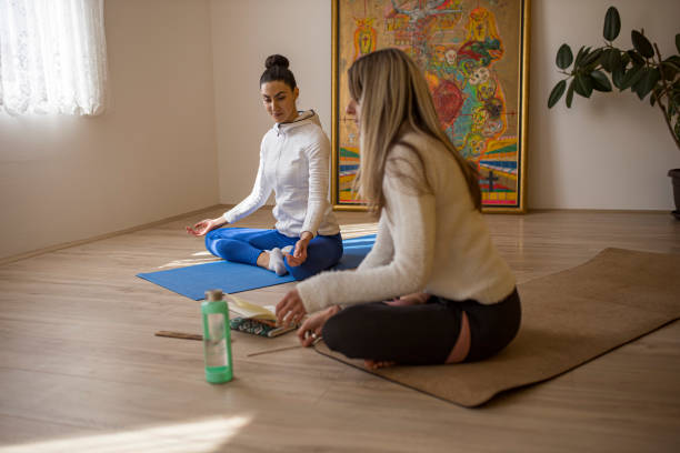 istock Two women practicing yoga at home 1306548176