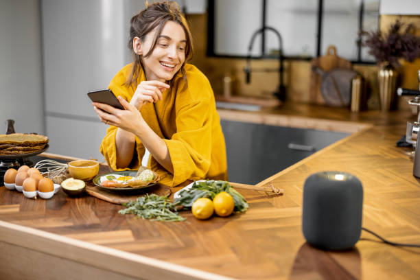 istock Woman speaking to a smart speaker during a breakfast at home 1306548786