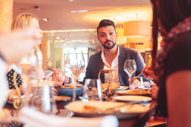 istock Host talking to his guests over lunch 1306550413