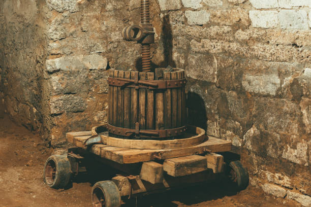 Photo of an old vintage wooden winepress near in a big stone cellar. Photo of an old vintage wooden winepress near in a big stone cellar moldova photos stock pictures, royalty-free photos & images