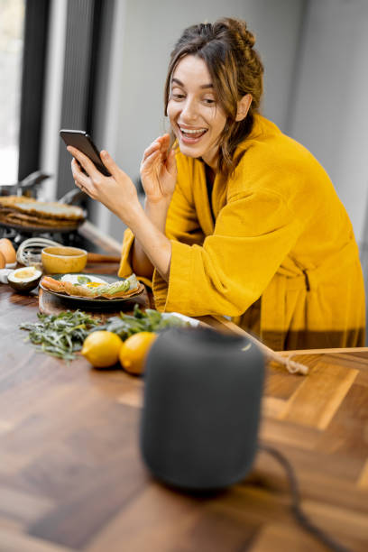 istock Woman speaking to a smart speaker during a breakfast at home 1306551252