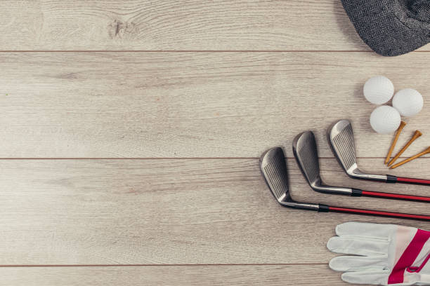 Golf equipment on wooden table background Golf clubs, tee's, golf balls, golf glove and hat on wooden table background. Flat lay concept. No people. golf glove stock pictures, royalty-free photos & images