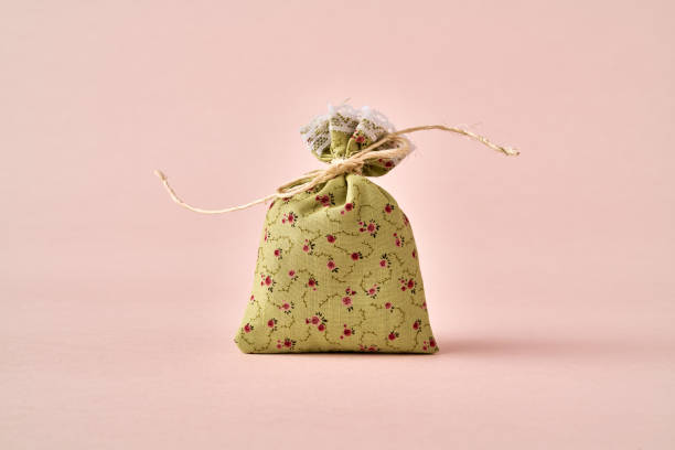 Three rag gift bags with a heart and a bow on a red faded background, top view with copy space. Holiday concept.