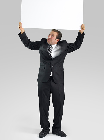 Businessman holding placard.
