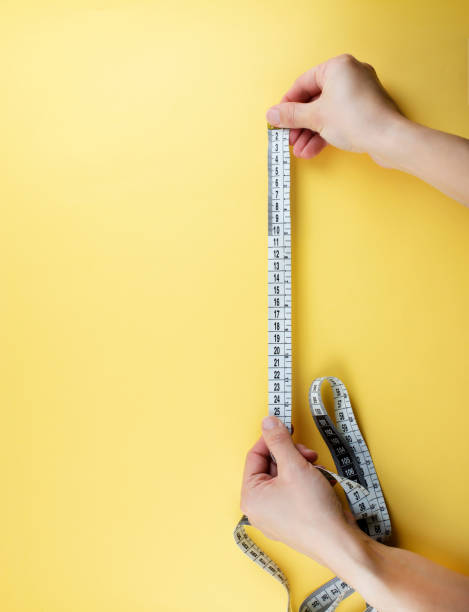 istock Measuring tape on yellow background. 1306555860