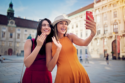 Happy girlfriends are making video call in the center of Vienna