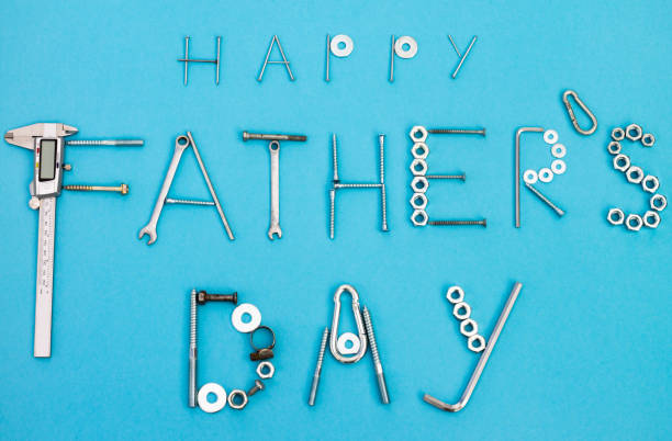 istock Text Happy Father's Day lined with bolts, nuts and other construction tools on a blue background. Flat lay. Top view. 1306556056