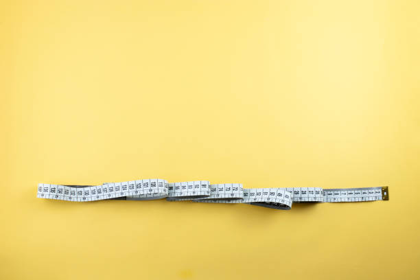 istock Measuring tape on yellow background. 1306556286