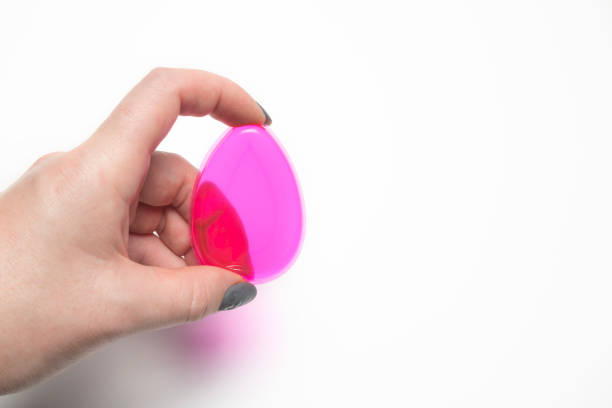 istock Woman hand holding silicone foundation sponge on a white background 1306557287