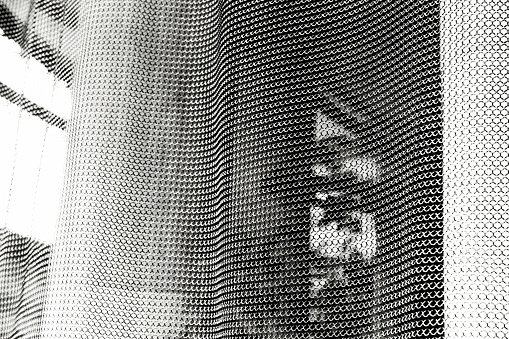 Black and white closeup metal mesh curtain, abstract background with copy space, full frame horizontal composition