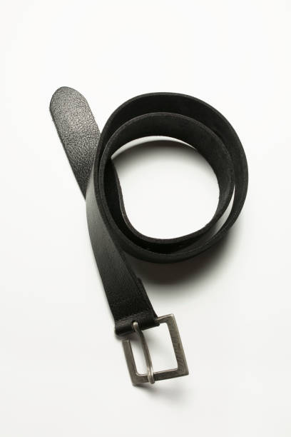 istock Black leather belt lying on a white background. Closeup shot 1306557434