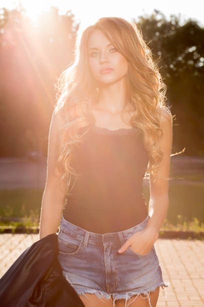 istock Glamor young model with lush wave hair posing in rays of sun 1306558704