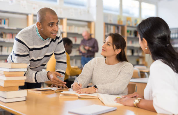 istock Latin American man with female friends studying in university library 1306559090