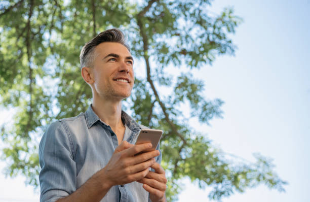 istock Smiling mature man using mobile phone, shopping online 1306561008