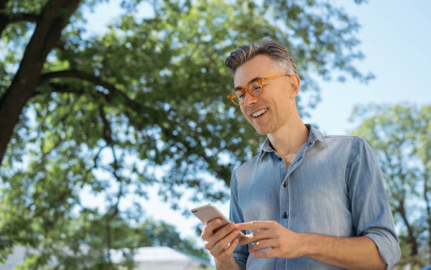 istock Stylish mature man using mobile app for online shopping 1306561010