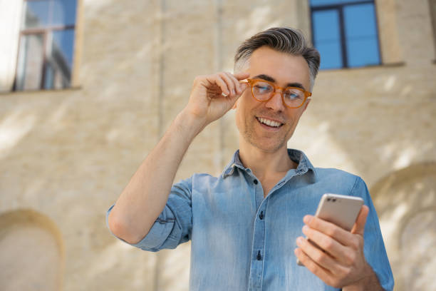 Handsome mature businessman holding smart phone
