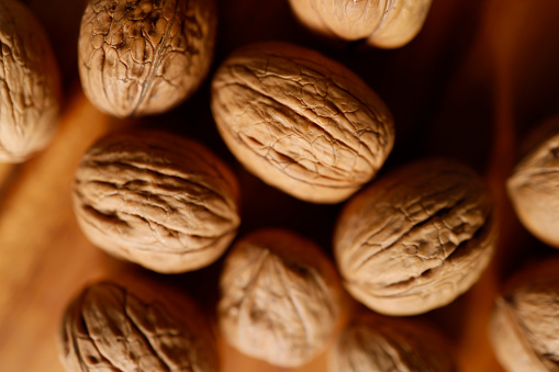 Istanbul, Turkey-March 10, 2021: Walnuts on a brown wooden background. The walnuts are shelled. Full Frame, Still life, Studio shot, Flat lay. Shot with Canon EOS R5, Canon RF 35mm Lens.