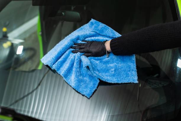 istock Polishing the car glass with a blue microfiber cloth. 1306563403