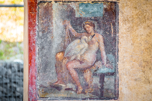 Pompeii, Italy : 2023 November 16 : Painted frescoes at the Ancient Pompeii (UNESCO World Heritage Site). Paving stones of Via del Foro in November 2023.