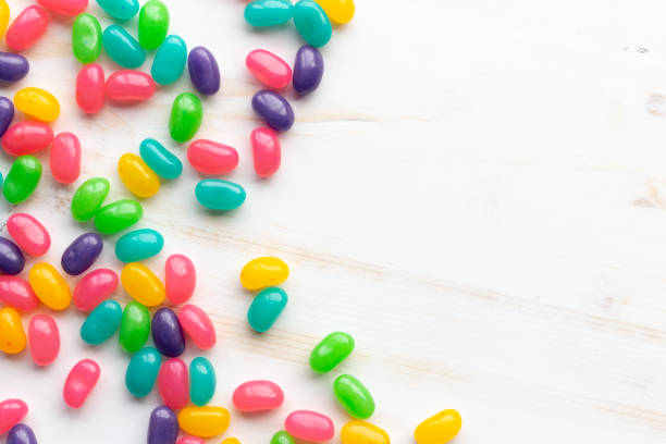 Jelly bean candy on white Multicoloured Jelly bean candy on white wood background with copy space jellybean stock pictures, royalty-free photos & images