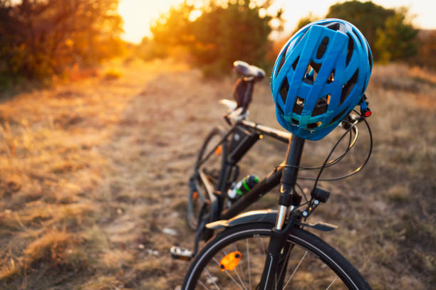 Close-up of a bicycle and cycling helmet in nature Photograph of a bicycle in nature. cycling helmet stock pictures, royalty-free photos & images