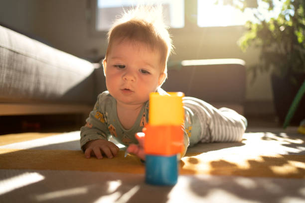 istock Baby boy playing with toy blocks on the floor 1306566794